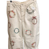 Free People cream barrel jeans with colourful embroidered wreath motifs, front