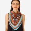 Inouitoosh Neptune square scarf in golden brown worn knotted at the neck, with aqua border