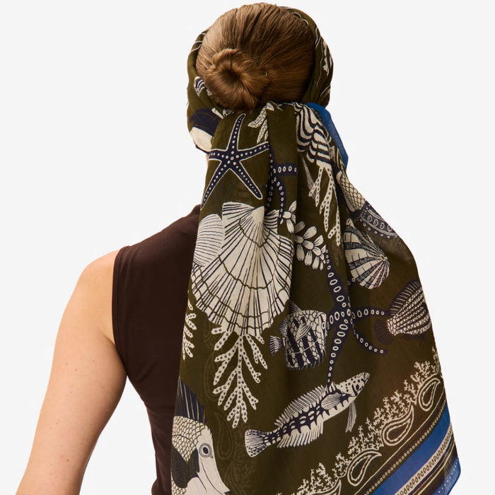 Inouitoosh Neptune square scarf in khaki, worn as a headscarf over a low bun