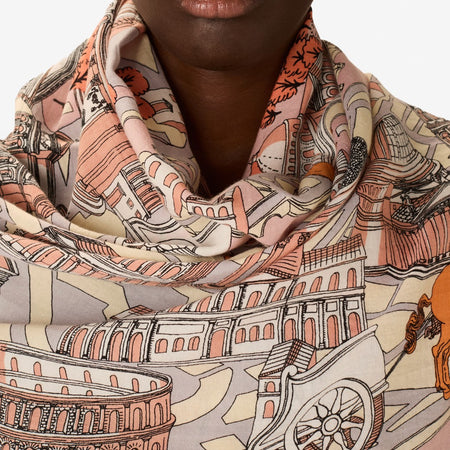 Inouitoosh Rome cotton and silk scarf in powder, worn wrapped at the neck, showing the Colosseum print