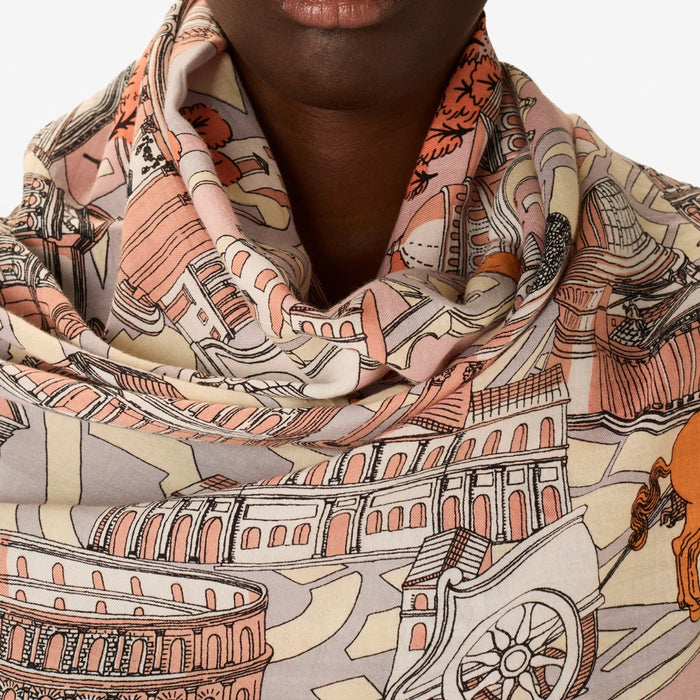 Inouitoosh Rome cotton and silk scarf in powder, worn wrapped at the neck, showing the Colosseum print