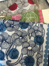 Les Belles Vagabondes Burma cotton square scarves in blue, red and pink, folded in store