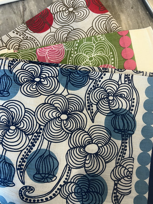 Les Belles Vagabondes Burma cotton square scarves in blue, red and pink, folded in store