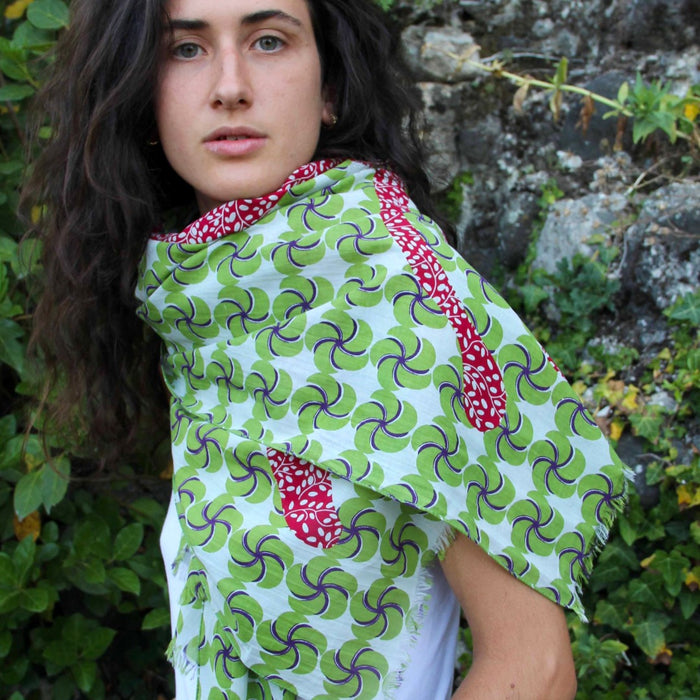 Woman wearing a Les Belles Vagabondes cotton scarf in green swirl print with red trim