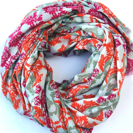 Les Belles Vagabondes large cotton scarf in orange, pink and sage print, loosely coiled