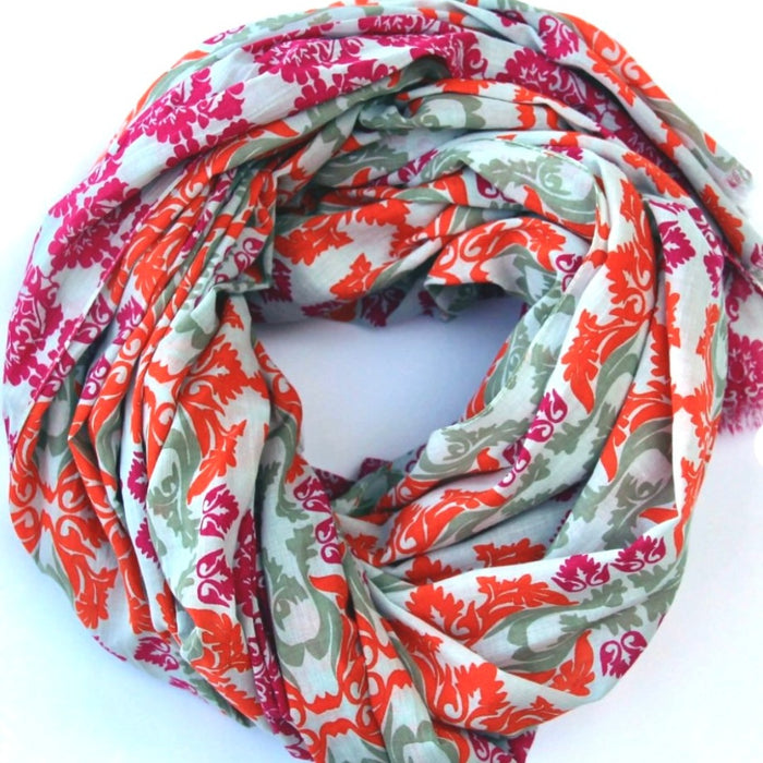 Les Belles Vagabondes large cotton scarf in orange, pink and sage print, loosely coiled