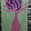 Les Belles Vagabondes cotton scarf with a pink tree print on green, hanging against stone