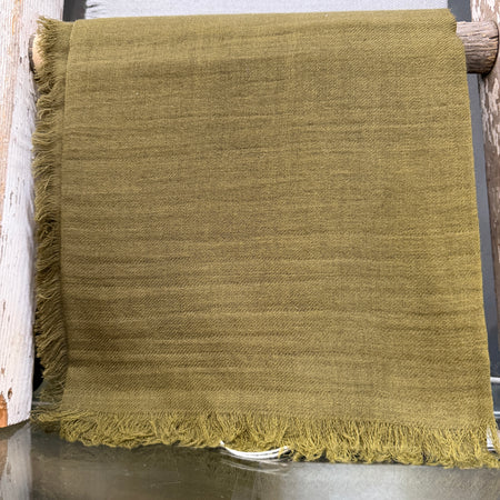 Manuelle Guibal Jowool fringed wool scarf in olive green, hung on a rail