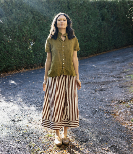Metta Melbourne Ash A-line skirt in coco stripe, worn outdoors with an olive top