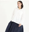 Metta Melbourne Fisherman shirt in white, worn with a navy skirt