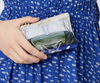 Nancybird printed zip card purse held against a blue floral dress