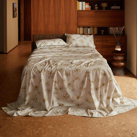 Nancybird cotton flat sheet in tea tree print on a made bed