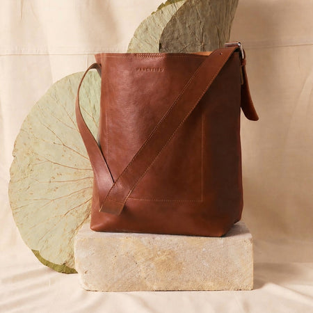 Nancybird Jou leather tote bag in natural tan, styled on a stone block