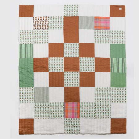 Nancybird geo patchwork kantha quilt in rust, green and white, hand-stitched cotton, laid flat