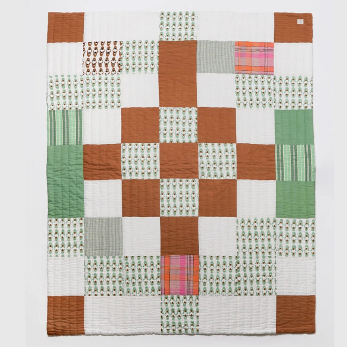 Nancybird geo patchwork kantha quilt in rust, green and white, hand-stitched cotton, laid flat