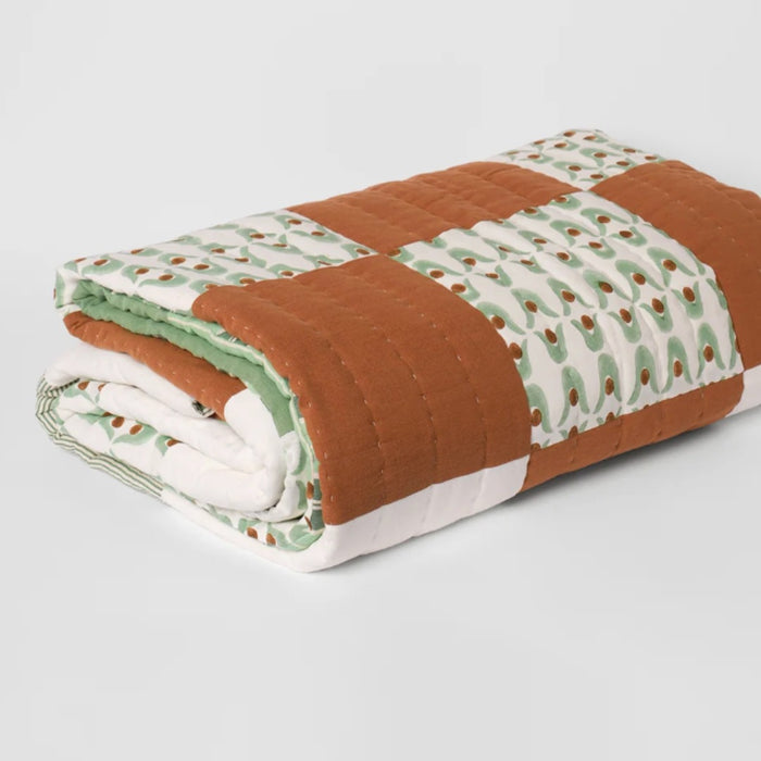 Nancybird geo patchwork kantha quilt folded, showing the hand stitching and printed patches