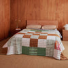 Nancybird geo patchwork kantha quilt on a double bed in a timber-lined bedroom