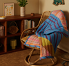 Nancybird raspberry stripe kantha quilt draped over a rattan chair