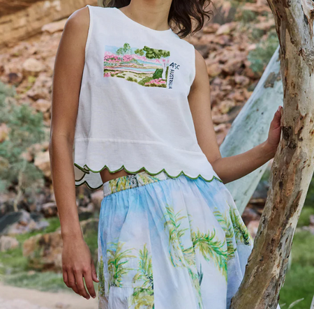 Model wearing the Nancybird Moa white tank top with a printed skirt, outdoors