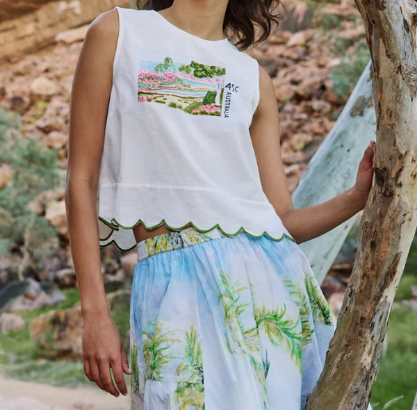 Model wearing the Nancybird Moa white tank top with a printed skirt, outdoors