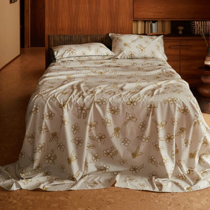 Nancybird tea tree print cotton bedding on a bed in a timber bedroom
