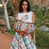 Model holding the Nancybird stamp tote bag in pale blue, outdoors