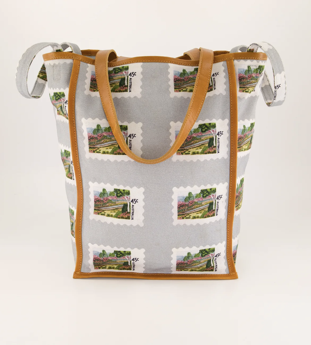 Nancybird stamp tote bag in pale blue with postage stamp print and tan handles