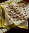 Nancybird geo flower print tea towel laid on a tiled bench