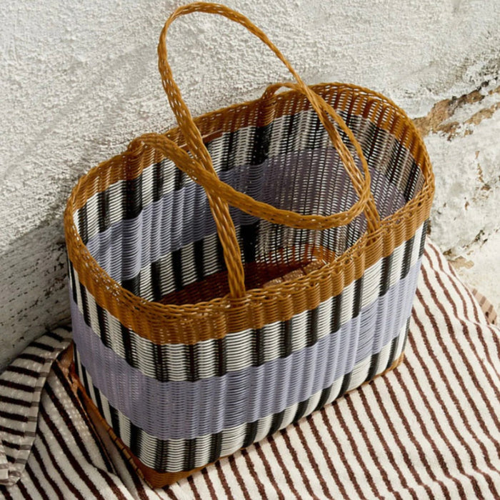 Palorosa Mercado handwoven market basket in blue lilac and tobacco, against a white wall