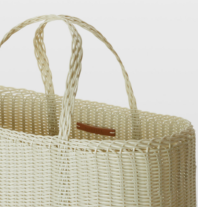 Wicker basket with a handle on a light background