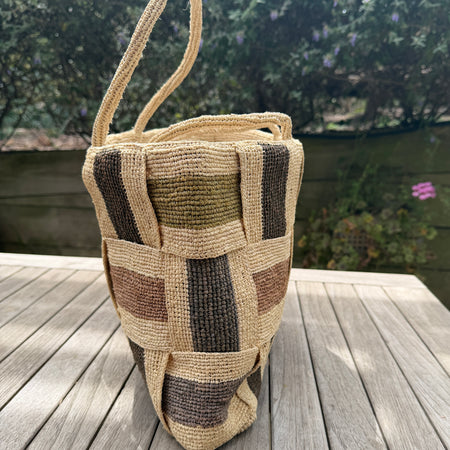 Woven bag with a checkered pattern on a wooden surface