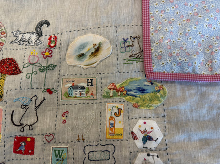 Rebecca Manning hand stitched baby quilt in linen and cotton on a dotty background