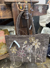Sophie Digard brown floral crocheted raffia tote hanging in the Pomme shop