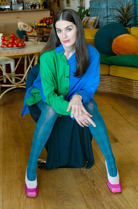 Model wearing Tightology Pine blue patterned cotton tights with green shirt and pink heels