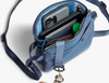 Bellroy City Pouch crossbody bag in blue, open with a phone and keys inside