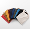 A collection of colorful cotton canvas crossbody bags with a strap, displayed in an over-the-shoulder style. Bags come in various solid colors including red, yellow, blue, green, brown, and black.