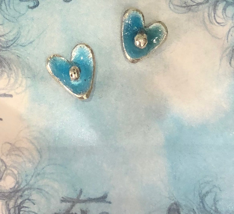 Flick Pope aqua enamel heart stud earrings on a blue background